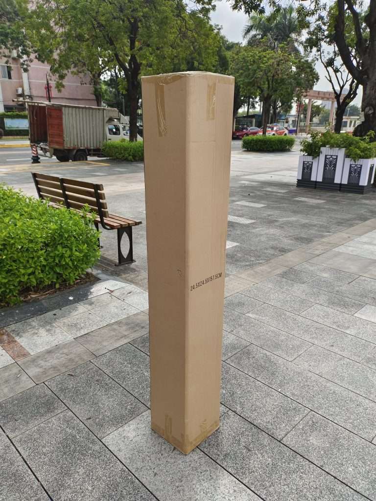 A cardboard box sitting on the ground in a city.