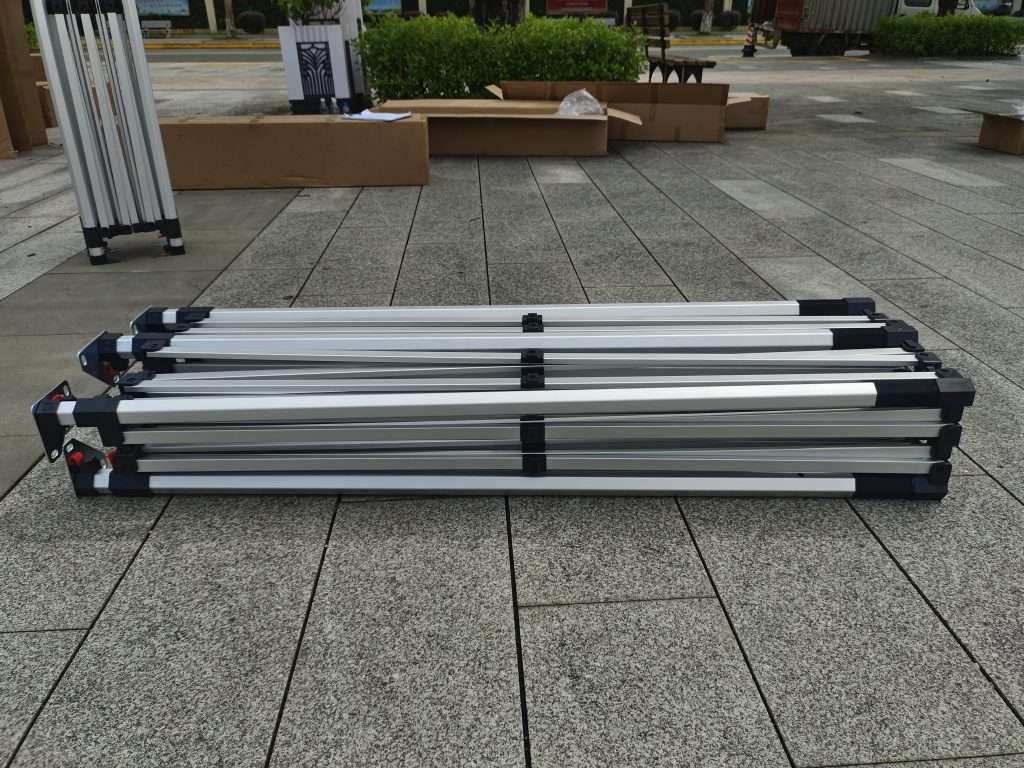 Four aluminum luggage stands on a sidewalk.