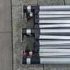 A group of four metal poles sitting on the ground.