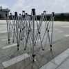 A group of metal poles on a sidewalk.