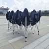 A group of chairs with black covers on them.