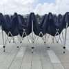 A group of chairs with black covers on them.