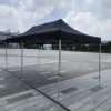 A black tent sitting on a concrete floor.