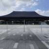 A black tent on a paved area.