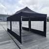 Outdoor tent with black walls and windows.