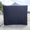 A black tent with white walls and a white roof.