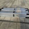 A group of four metal poles sitting on the ground.