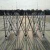 A group of metal folding chairs on a concrete floor.