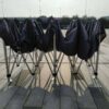 A group of chairs covered in black cloths.