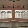 A tent with a white canopy and a black frame.