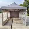 A tent with a white canopy and a black frame.