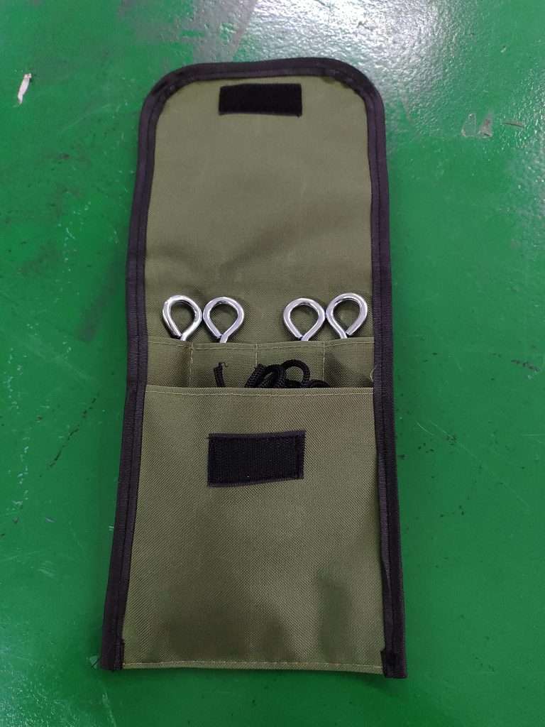 A pouch with four metal hooks and a pair of scissors.