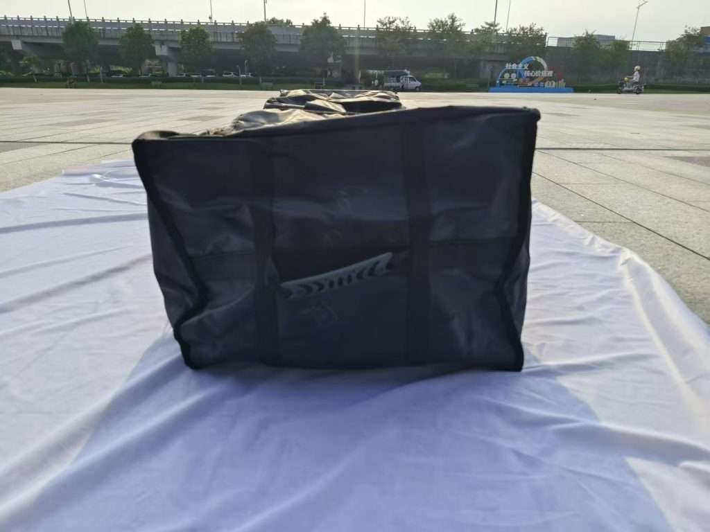 A large black bag sitting on top of a white sheet.