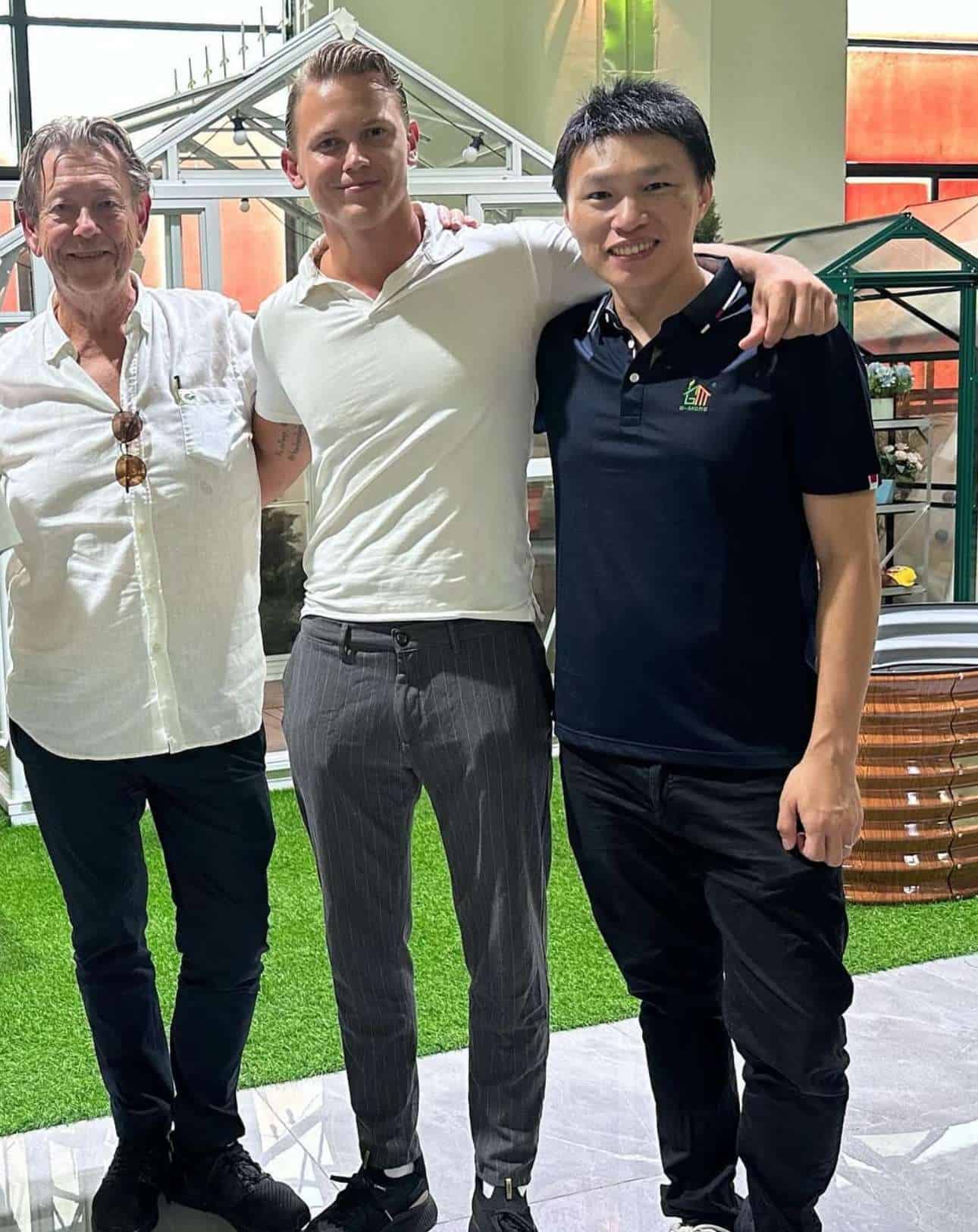 Four men standing next to each other in a room.