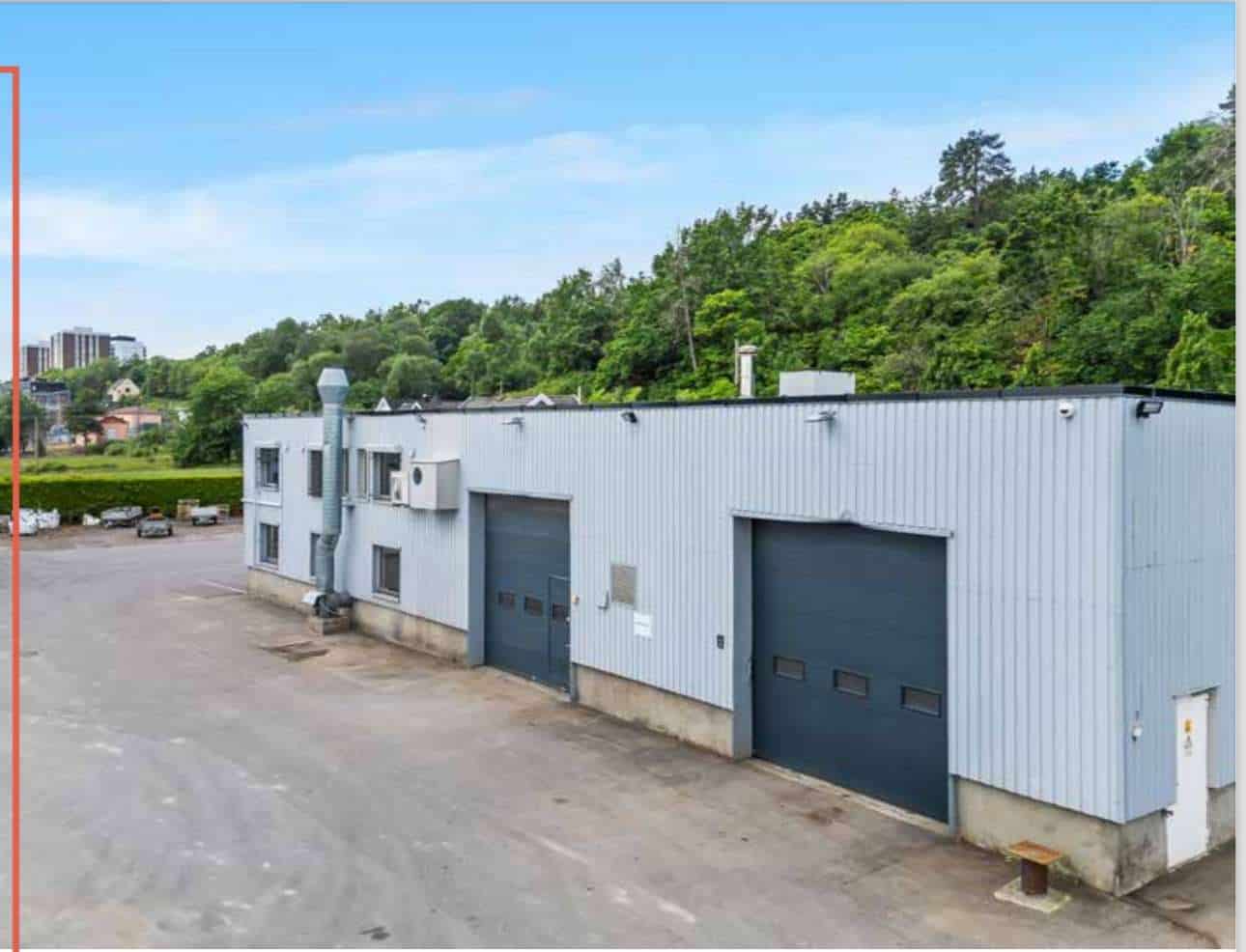 An industrial building with a red sign on it.