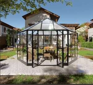 A glass enclosed gazebo in a backyard.