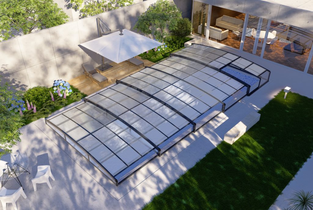 A glass enclosed pool with a patio area.