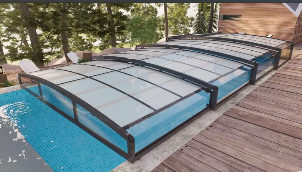 A pool with a glass enclosure and a deck.